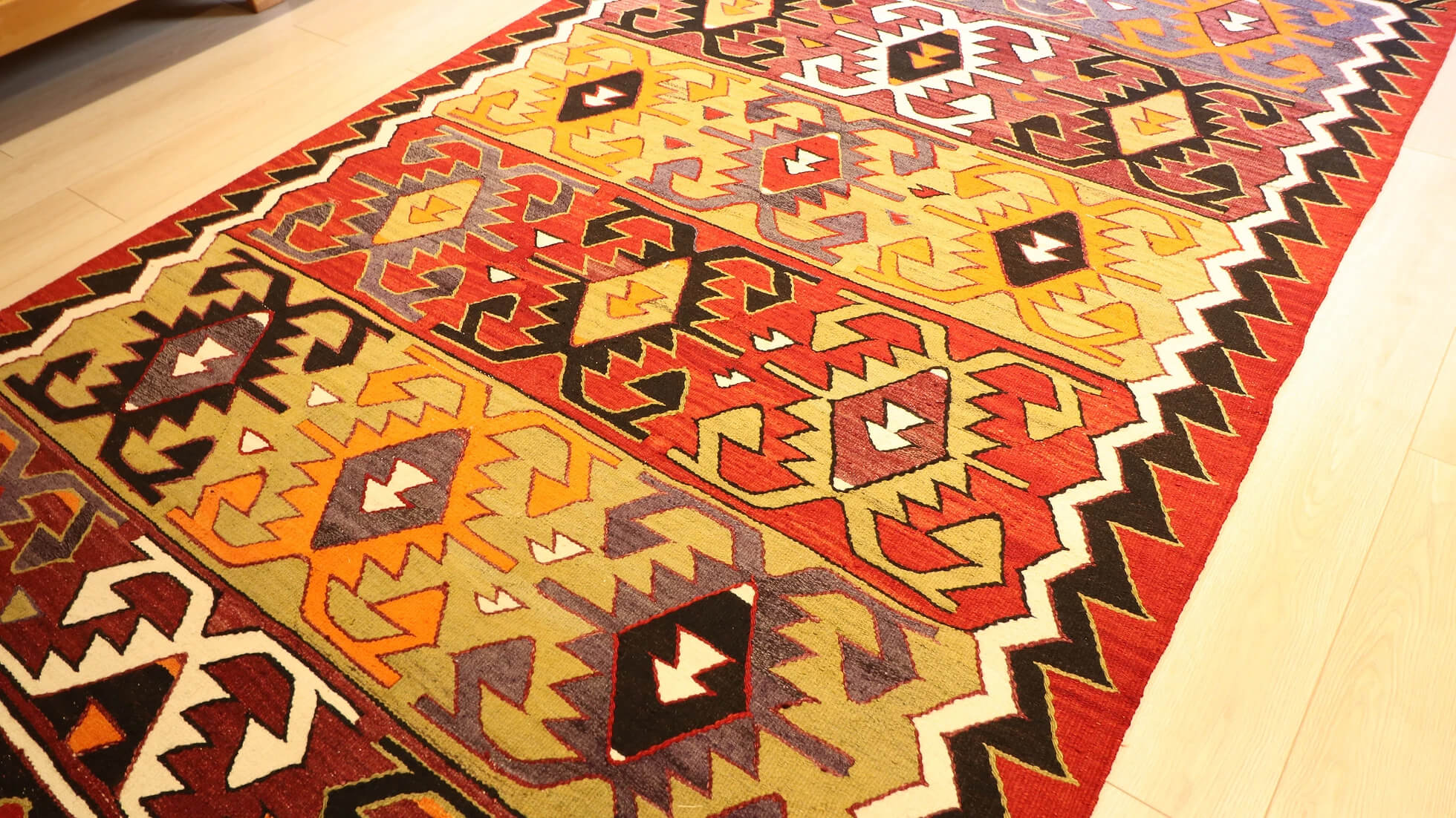 traditional hand-knotted Turkish rug from mid-century in red, black, green, and purple with geometric patterns