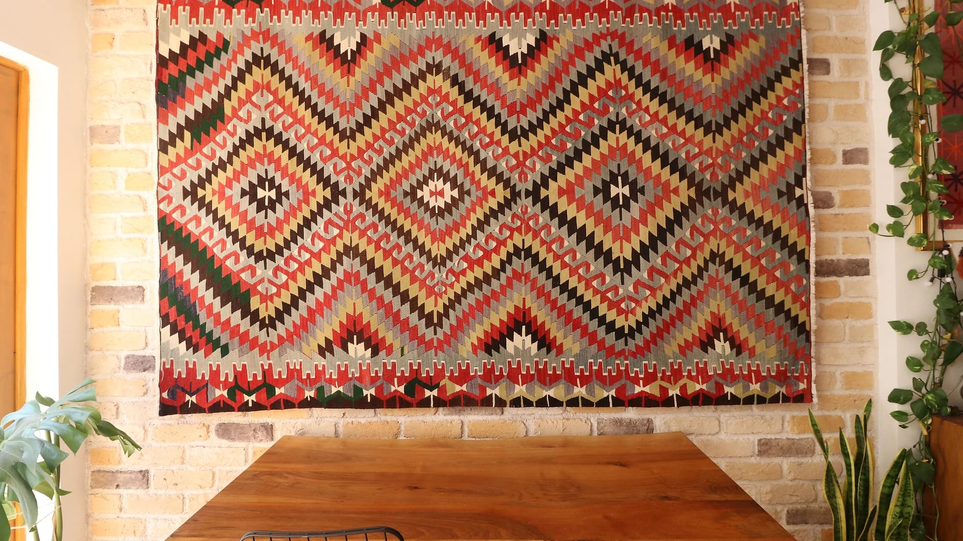 one-of-a-kind flat-woven Turkish rug in contemporary style with diamond and lozenge patterns in beige, red, and black hanging on the wall as a tapestry