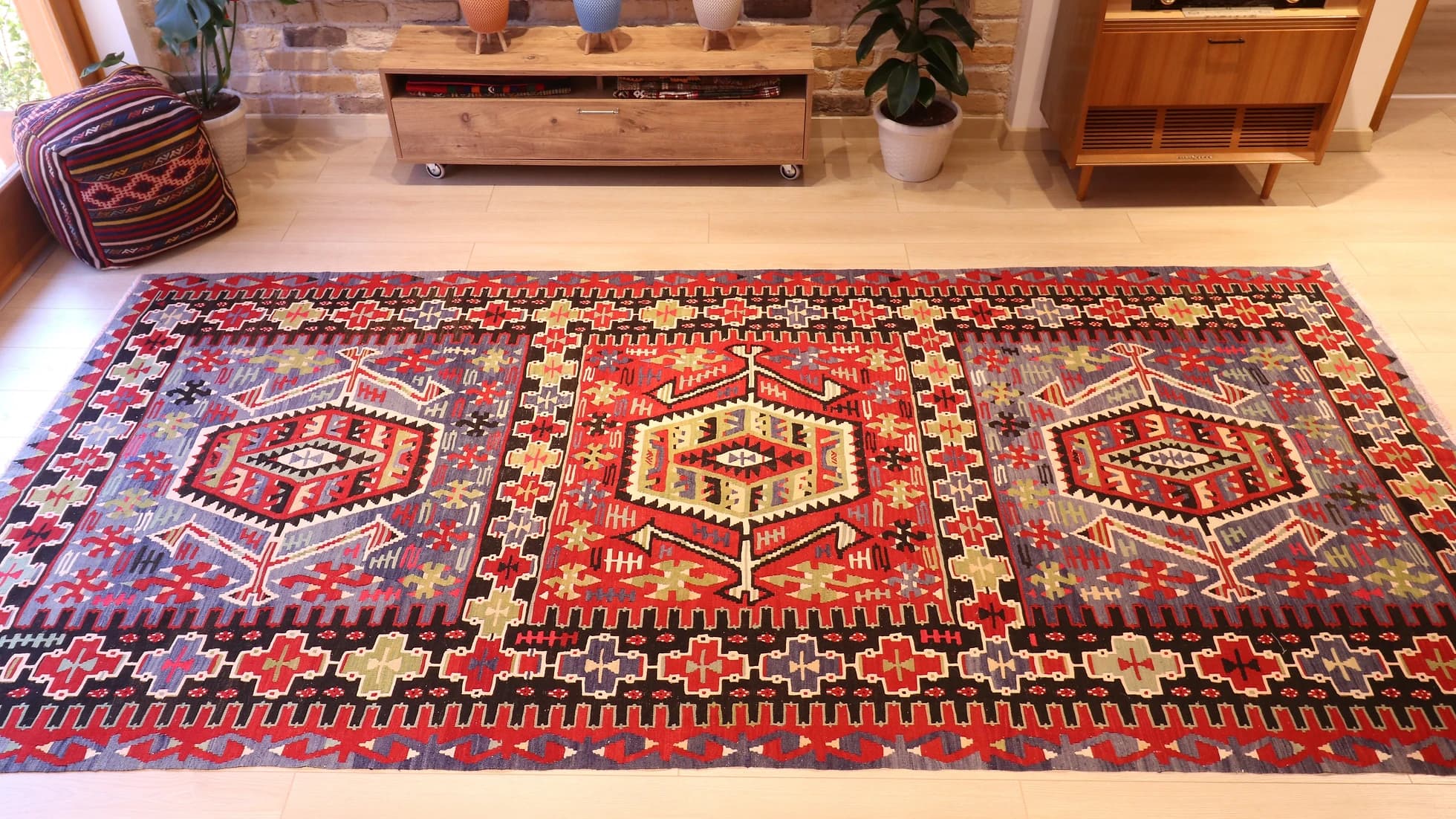 a rustic nomadic Turkish Esme Oushak Rug in many traditional motifs and earthy tones from the mid-century in a NYC rug gallery