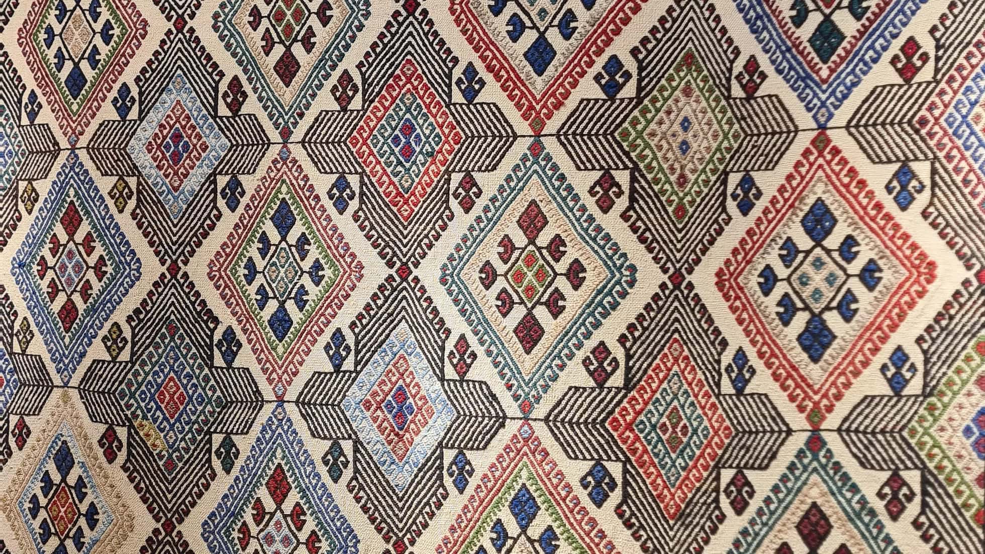 Mid-Century Medium Area Rug with a powerful 'elibelinde' motif, a tribute to fertility and motherhood, set against an Alabaster cream field.