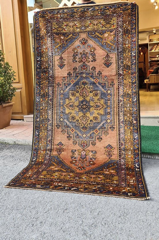 Mid-century Yahyali rug from Kayseri, Turkey, 3x7 ft, handwoven with 100% wool. Features a soft dusty peach background with a central floral medallion in powder blue and gold, surrounded by delicate floating motifs and a triple floral border. Crafted using natural dyes from madder root and walnut shells, showcasing traditional Turkish artistry and durable craftsmanship.