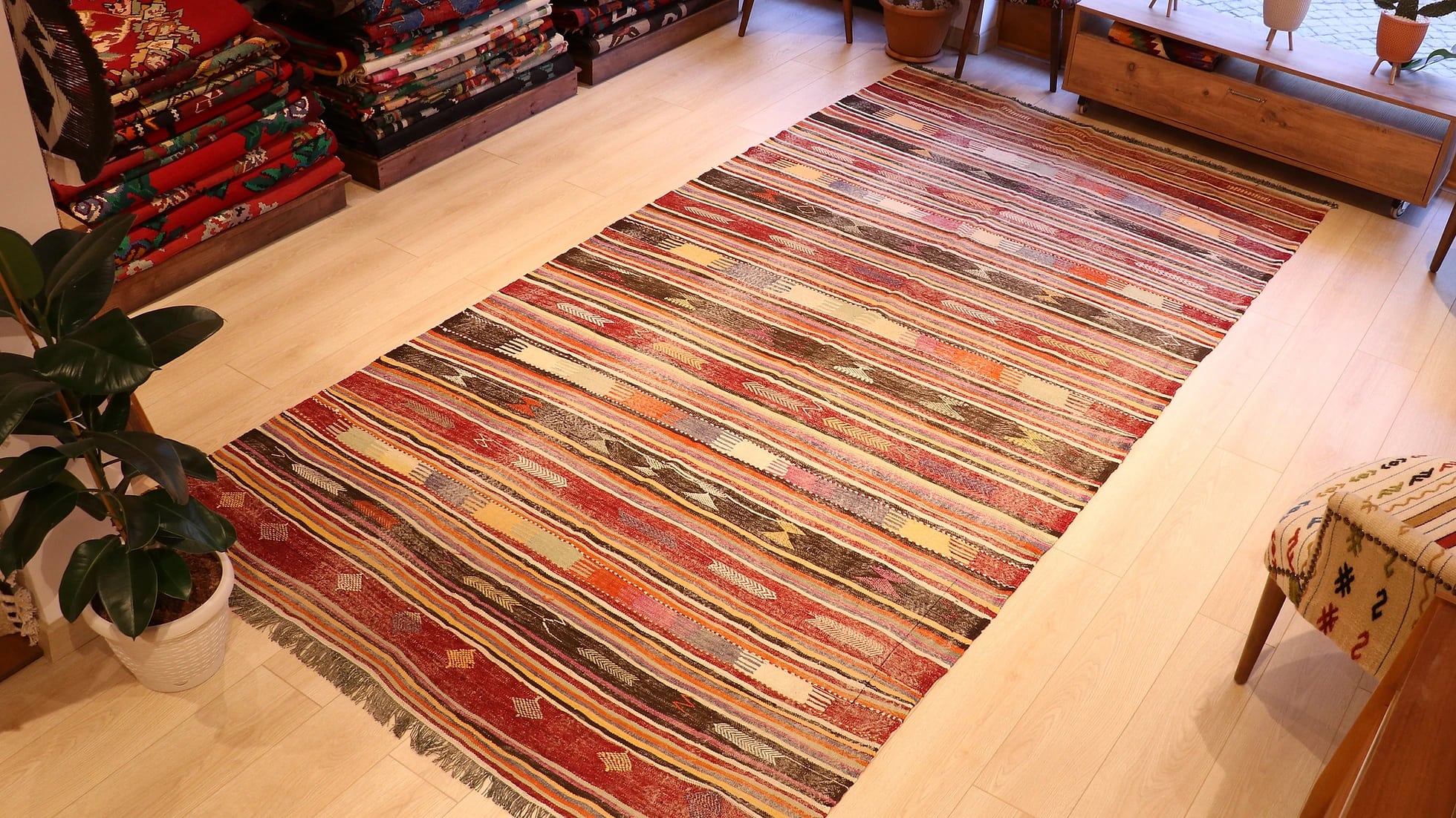an expansive traditional kilim runner rug in pastel and rustic earth tones with geometric stripe motifs