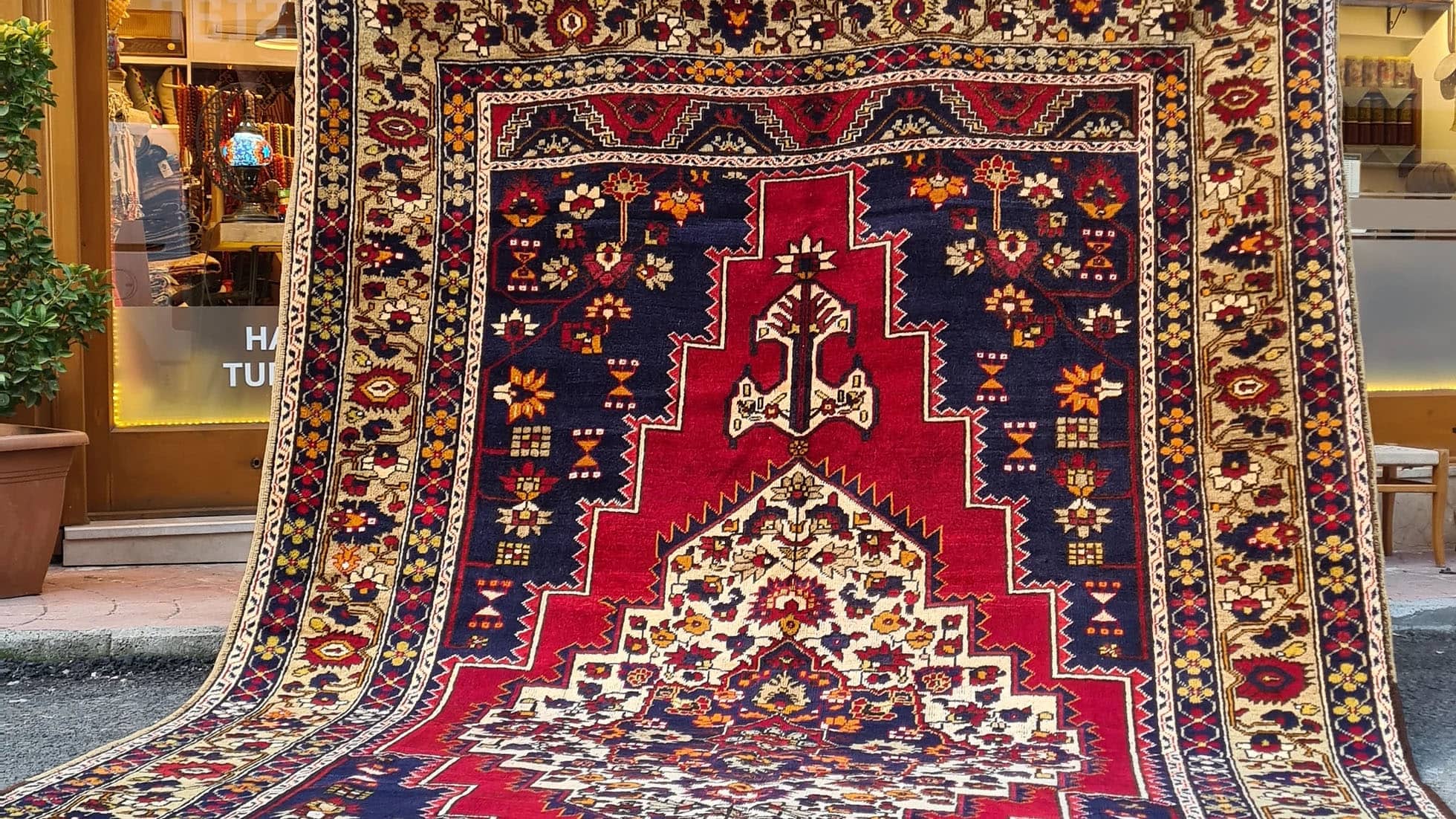 mid-century Turkish oriental wool rug in red, blue, and gold with floral patterns
