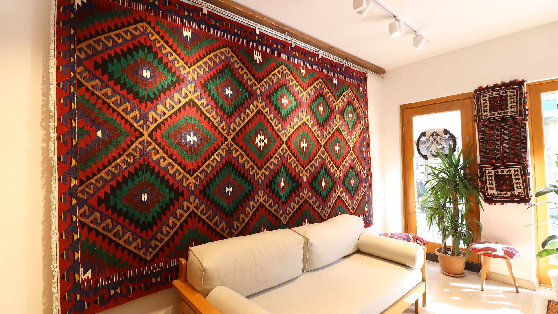 Vintage Anatolian Flat-Weave Rug. This rare 1950s Turkish kilim, measuring 7x11, showcases mythical 'dragon' motifs in rich terracotta red, deep green, and golden yellow, symbolizing strength and protection. Framed by symbolic 'comb' and 'running water' borders, this heirloom-quality wool rug seamlessly blends tradition with modern interiors, offering timeless artistry and cultural depth.