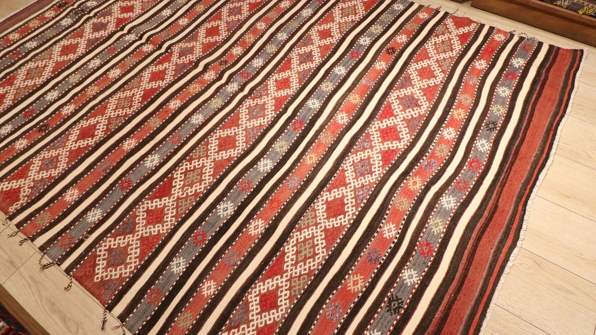 a magnificent and true authentic striped Turkish kilim rug in rustic earth tones like terracotta from the 1950s era by KCNY