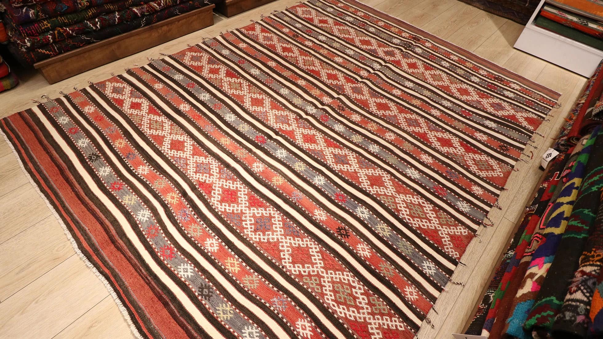 a magnificent and true authentic striped Turkish kilim rug in rustic earth tones like terracotta from the 1950s era by KCNY