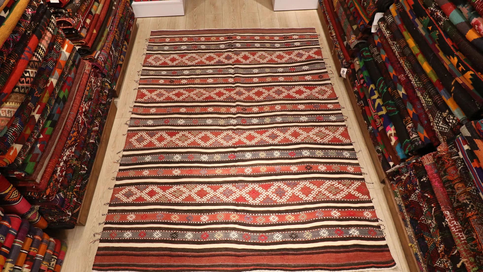 a magnificent and true authentic striped Turkish kilim rug in rustic earth tones like terracotta from the 1950s era by KCNY