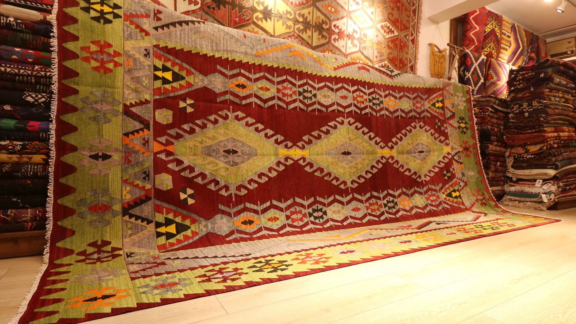 Vintage Turkish kilim runner rug from Fethiye, 8x11 ft, handwoven in the 1960s. Features vibrant lozenge motifs in pistachio, brick red, dove gray, yellow, and orange on a warm brick red background, framed by a double-layered border with intricate 'wolf's mouth' motifs. A rare and authentic piece of Turkish artistry.