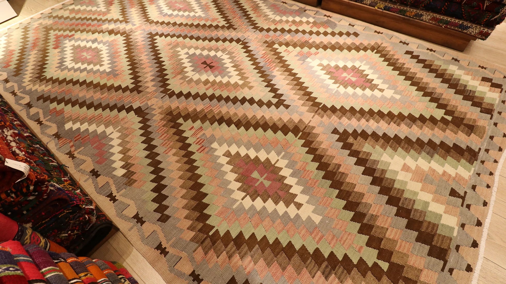 a rare large area rug from western Anatolia in pastel and neutral muted tones and diamond/lozenge patterns in our New York rug store