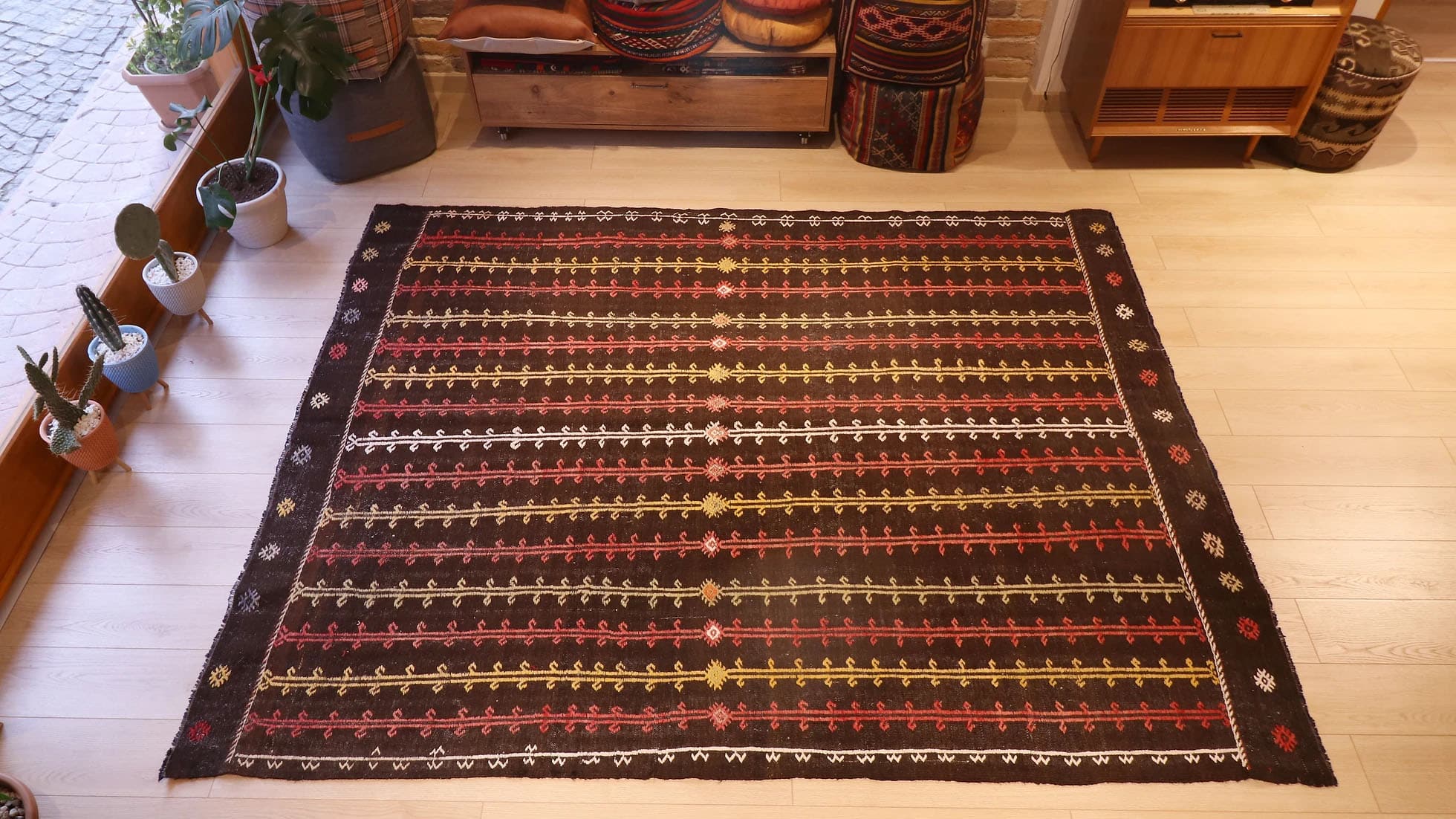 Rare vintage Turkish kilim rug, 6x7 ft, handwoven in wool circa 1950s. Features a rustic brown background with intricate latch-hook and burdock motifs in beige, rust, white, and earthy tones, showcasing traditional nomadic tribal craftsmanship and flat-weaving techniques.