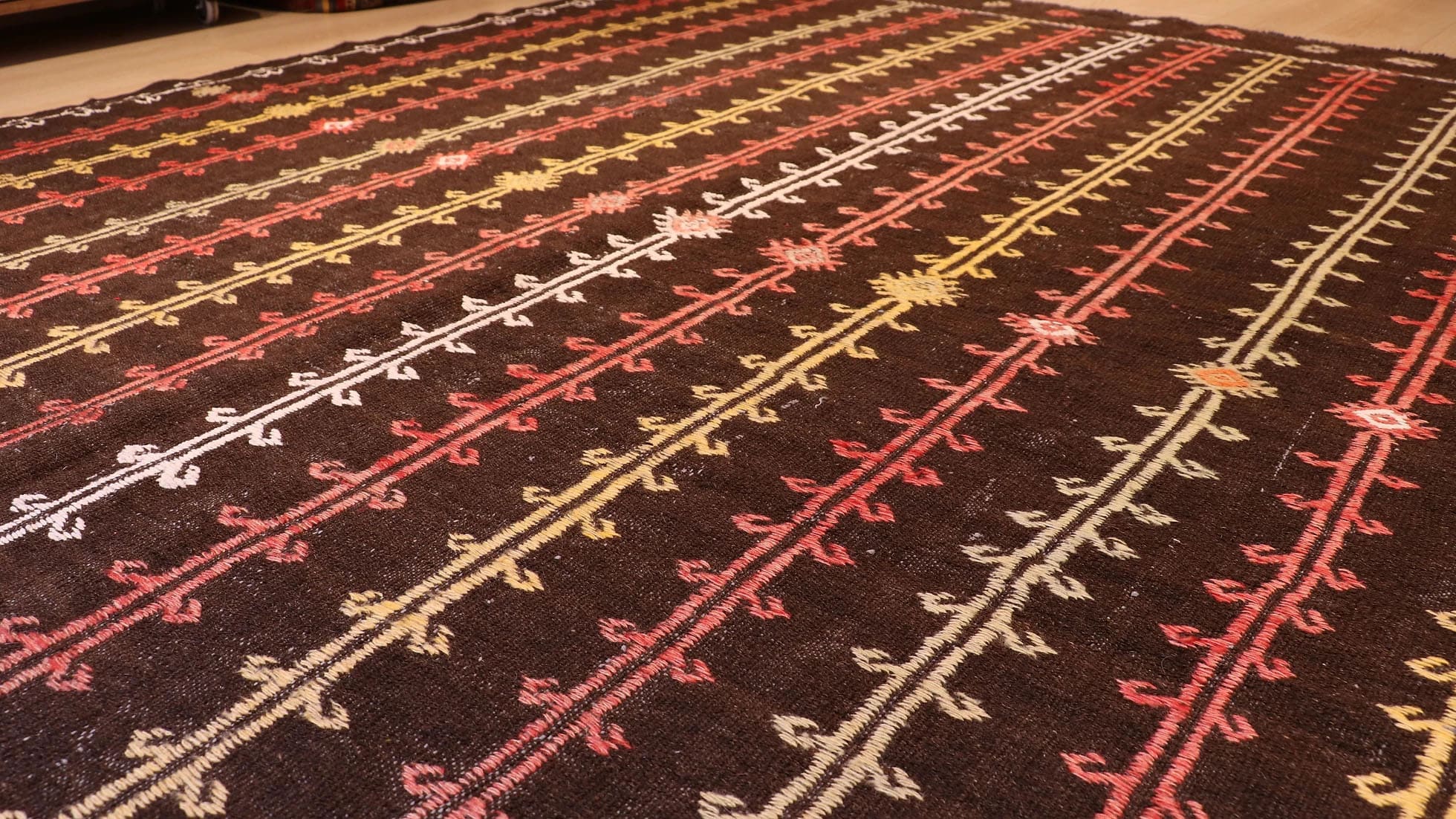 Rare vintage Turkish kilim rug, 6x7 ft, handwoven in wool circa 1950s. Features a rustic brown background with intricate latch-hook and burdock motifs in beige, rust, white, and earthy tones, showcasing traditional nomadic tribal craftsmanship and flat-weaving techniques.