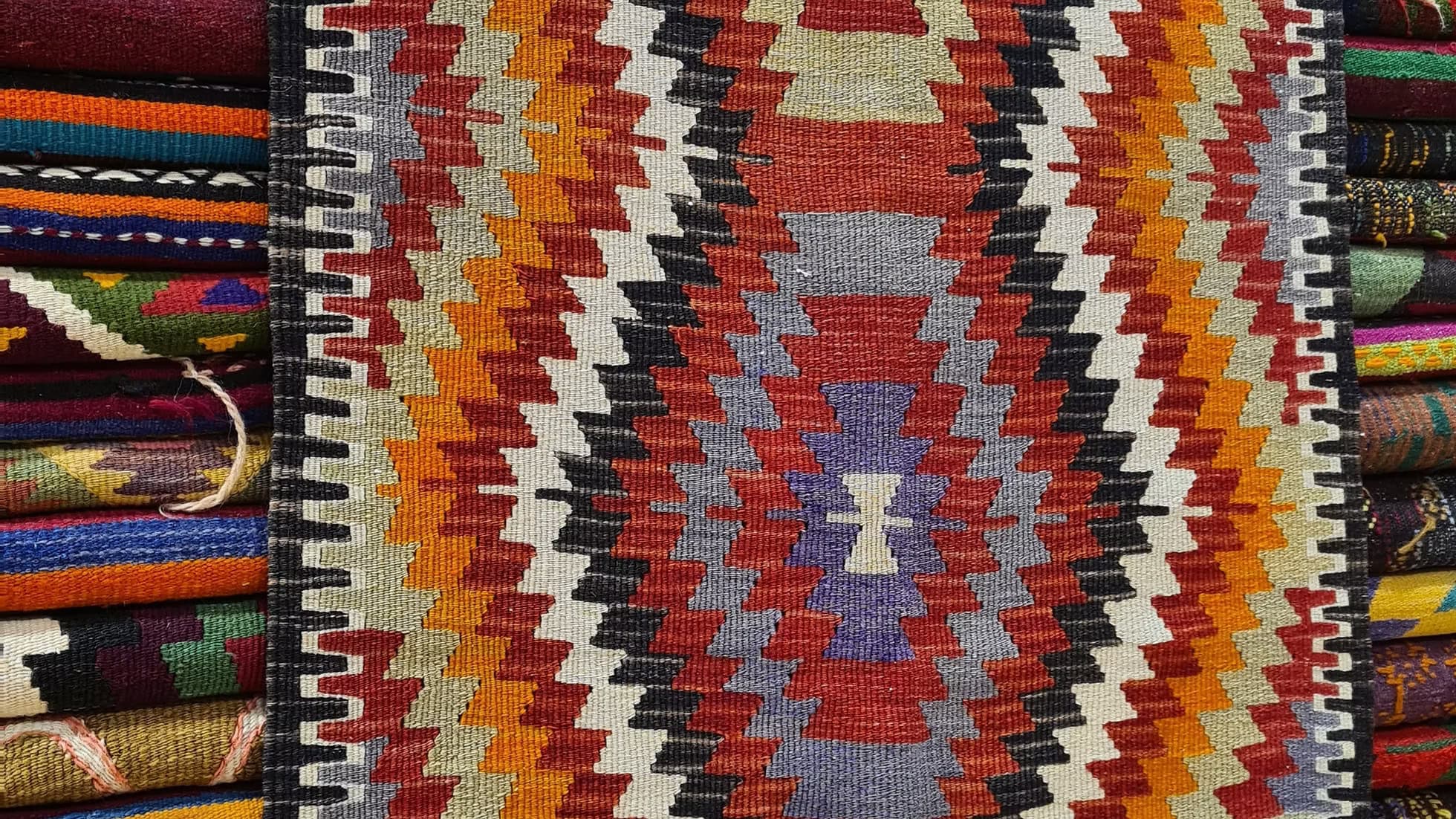 Vintage 1950s Turkish handwoven Antalya small kilim rug with Mediterranean diamond design orange, red green, gray.