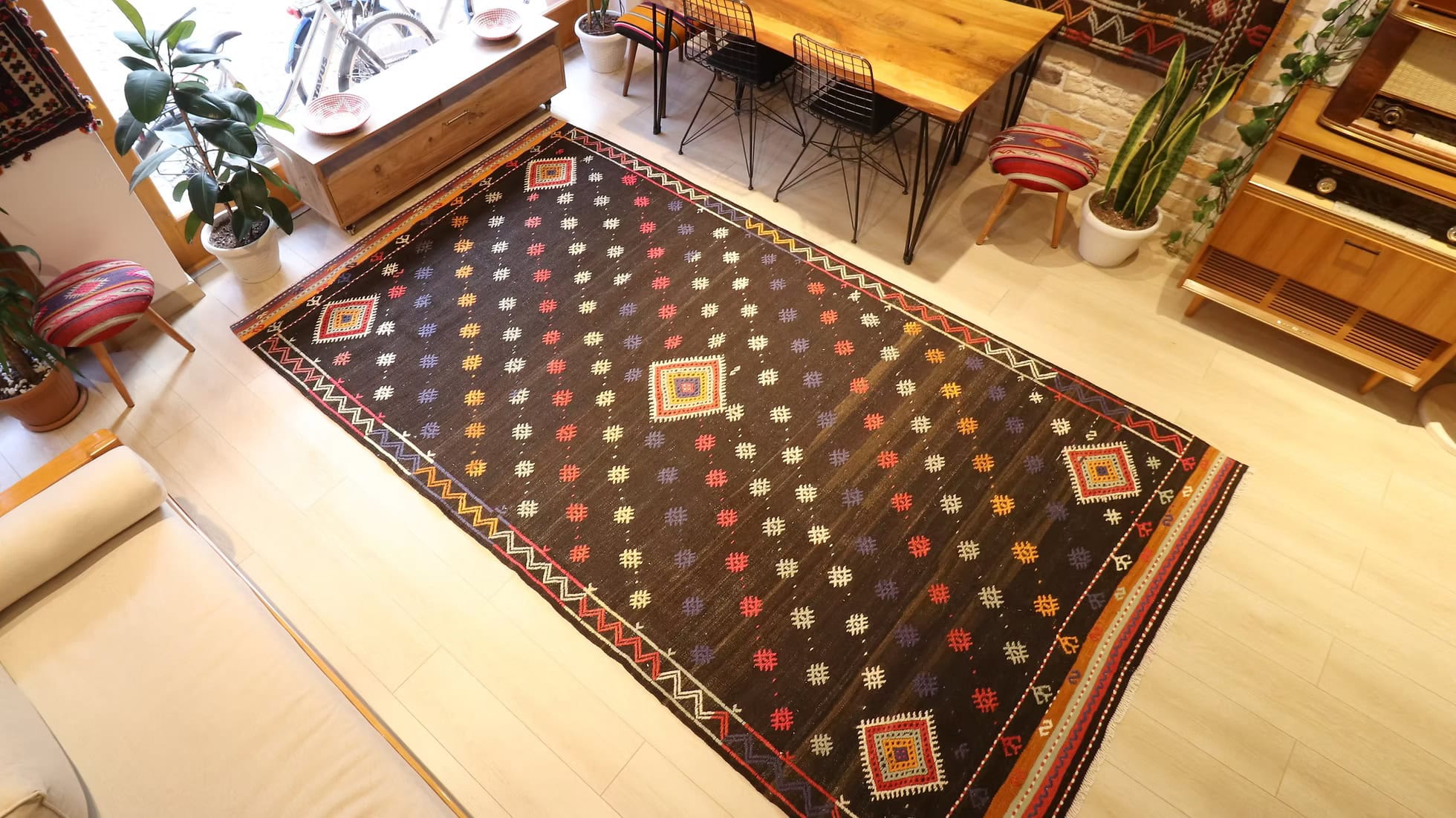 Rustic farmhouse and global-inspired vintage kilim showing aged patina, sun-washed discoloration, and intricate stripe borders.