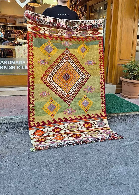 Vintage Turkish Aegean handwoven kilim in pastel pistachio, golden ochre, and soft mauve for luxury interiors