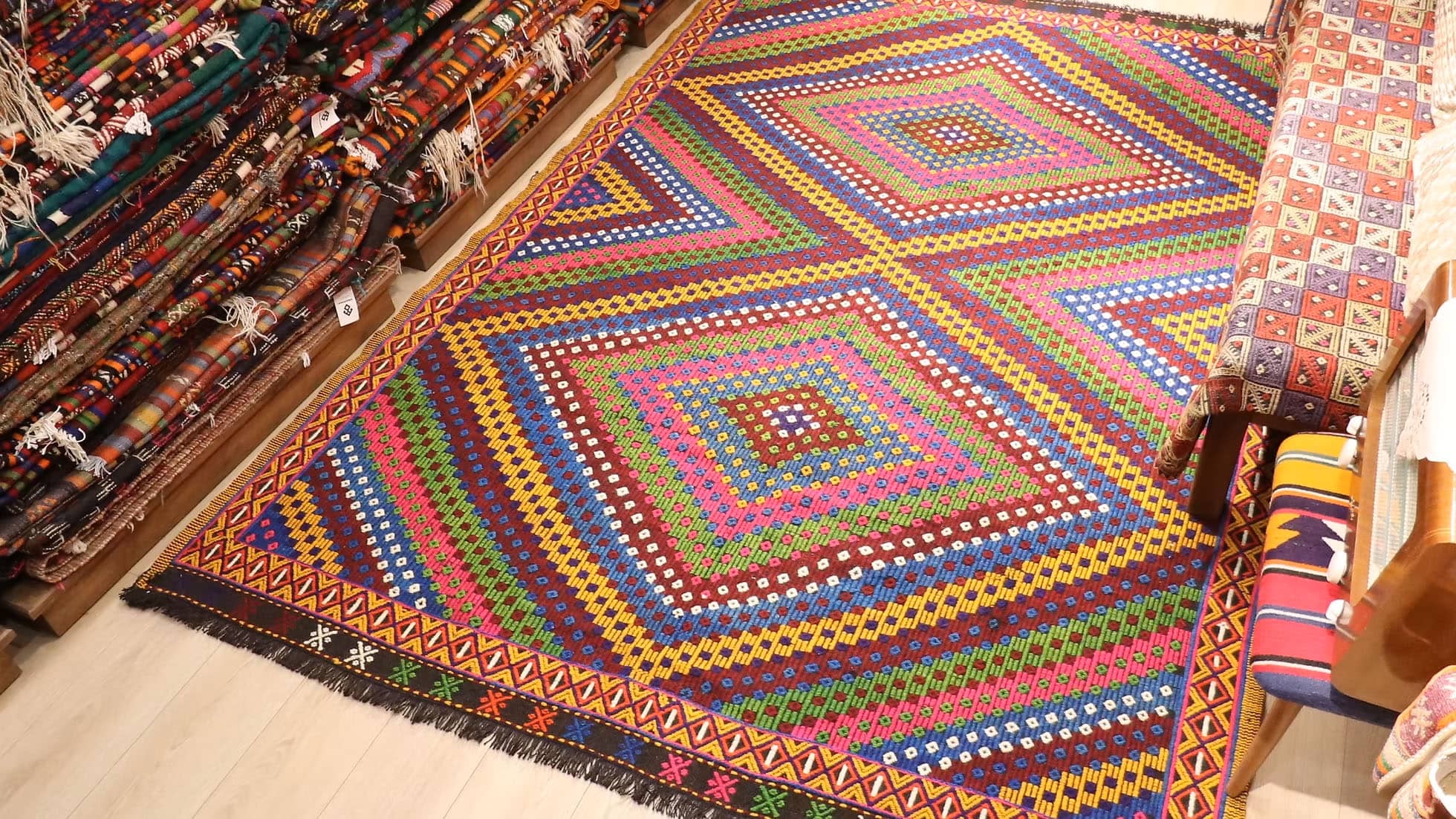 Vintage Soumak Flat-Woven Rug. Handwoven in Turkey circa 1950s, this 7x9 Soumak kilim showcases bold geometric patterns and a rich palette of burgundy, golden yellow, royal blue, and lush green. Featuring symbolic 'burdock' motifs and delicate tassels, this heirloom-quality wool rug bridges tradition with modern interiors, offering timeless artistry and lasting durability.