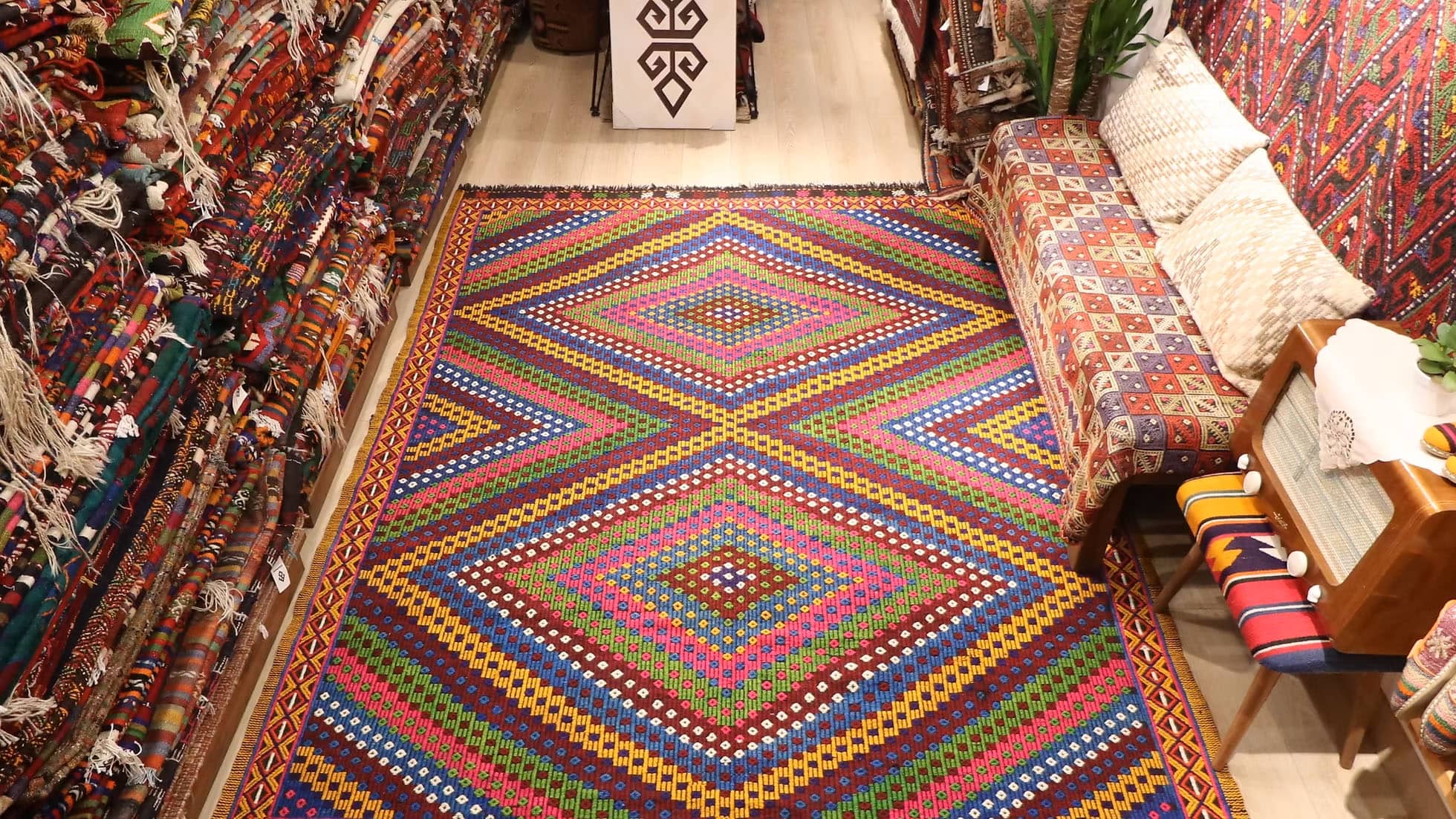 Vintage Soumak Flat-Woven Rug. Handwoven in Turkey circa 1950s, this 7x9 Soumak kilim showcases bold geometric patterns and a rich palette of burgundy, golden yellow, royal blue, and lush green. Featuring symbolic 'burdock' motifs and delicate tassels, this heirloom-quality wool rug bridges tradition with modern interiors, offering timeless artistry and lasting durability.