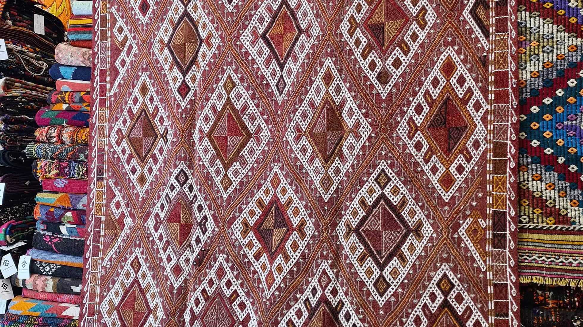 Handwoven mid-century Turkish area rug with geometric patterns, perfect for adding a touch of heritage and sophistication to NYC interiors by Kilim Couture New York.