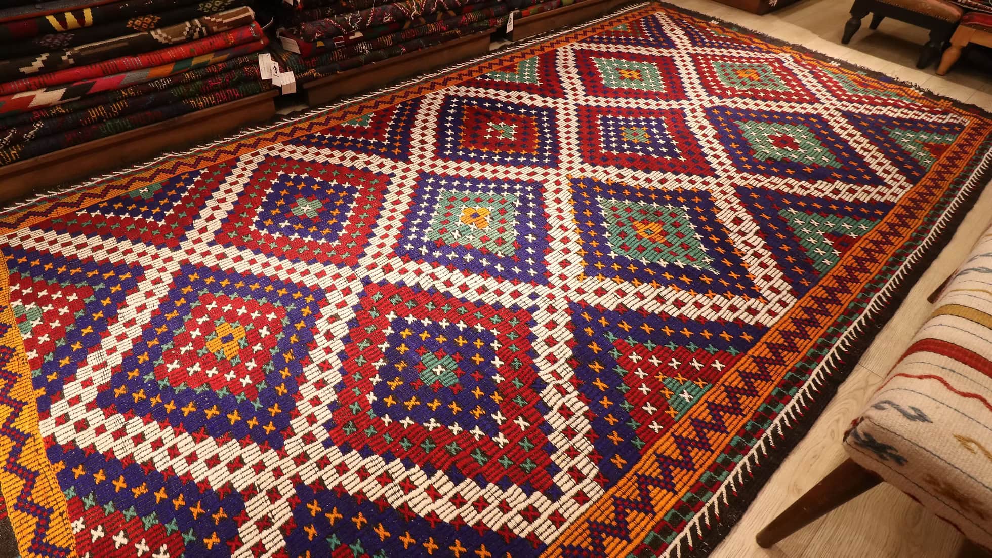 Colorful geometric-patterned Turkish rug on a wooden floor of Kilim Couture New York Rug Store