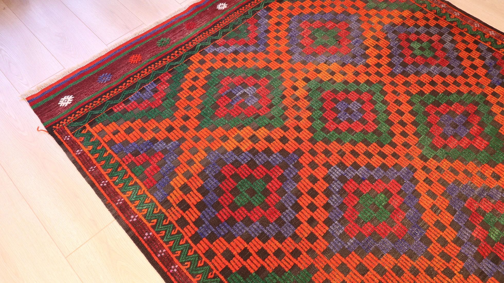 Vintage Turkish Cecim kilim rug from Manisa, 5x9 ft, handwoven in the 1970s using the rare cecim/jijim technique. Features lozenge motifs in burnt sienna, emerald green, royal purple, and fiery orange, with symbolic 'burdock' and 'running water' motifs, reflecting sustainable craftsmanship and cultural heritage.