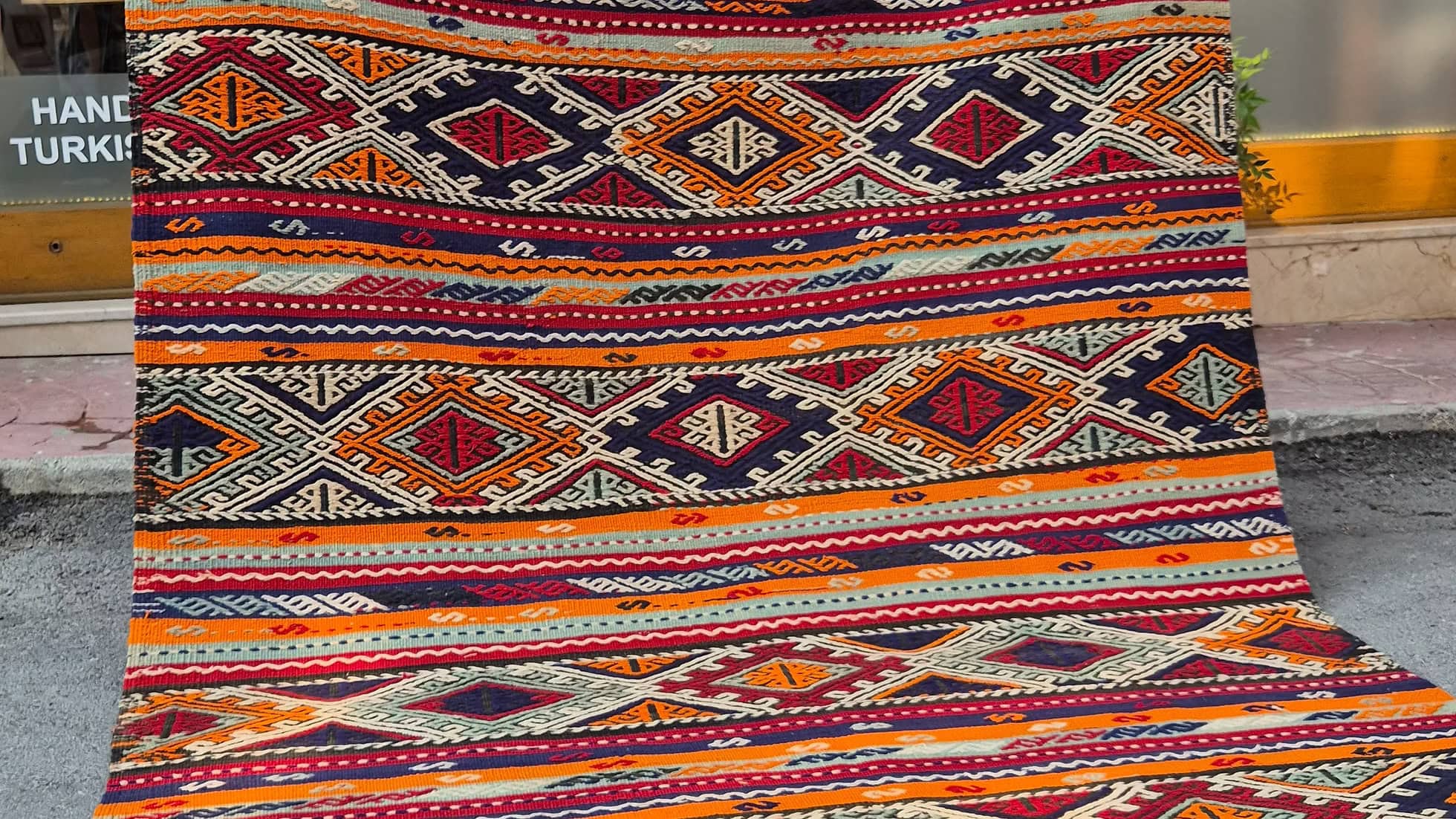 Sustainable tribal kilim rug in muted sun-baked orange, pomegranate blush, and marine blue tones by Kilim Couture Rug Store in NYC.