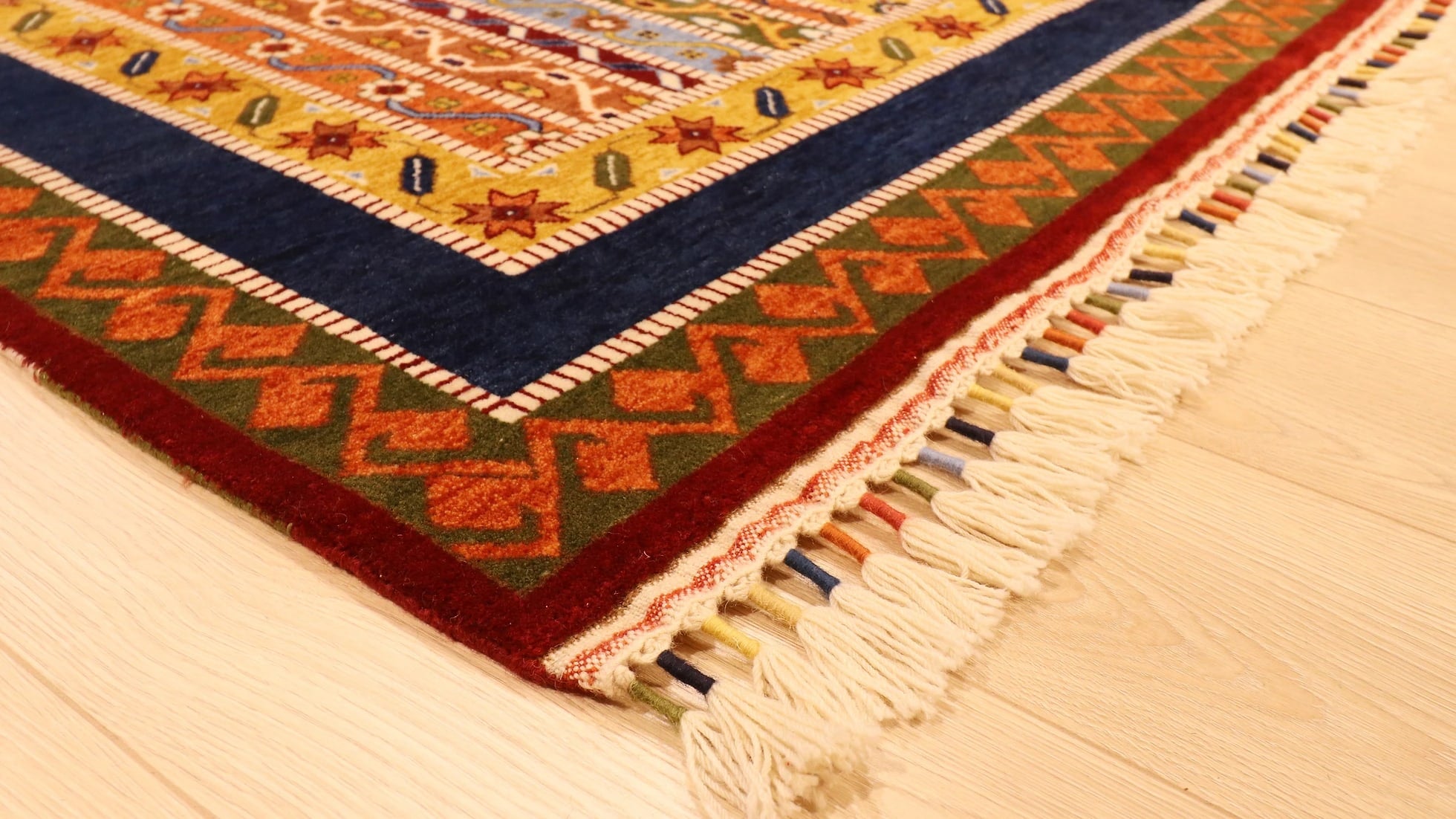 tassels of Turkish oriental ottoman palace style royal carpet in earthy tones with floral patterns